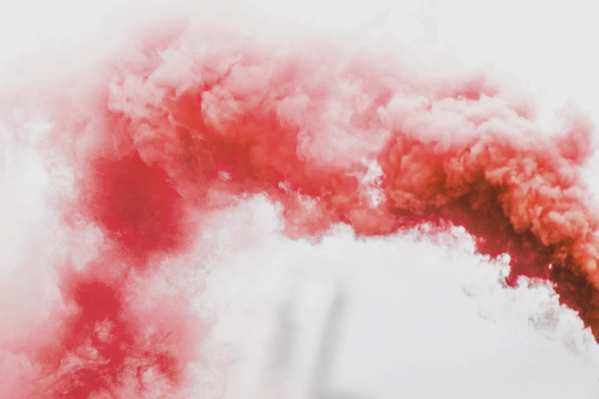 Roter Rauch / Roter Qualm vor hellgrauem Hintergrund